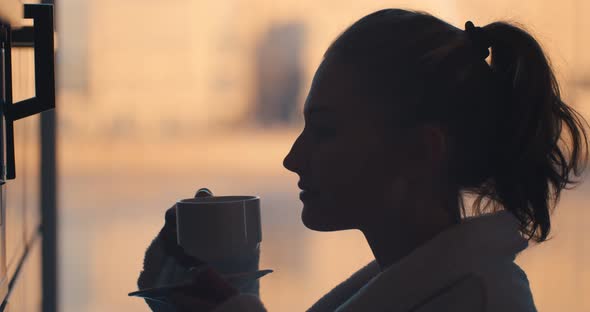 Side View of Woman in Bathrobe Preparing Delicious Aromatic Coffee in Coffee Machine alt