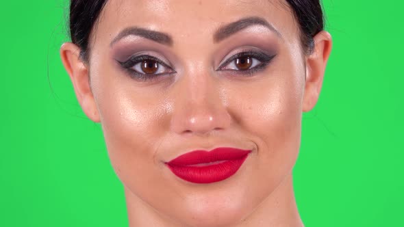 Portrait of Beautiful Woman Is Looking at the Camera Flirts, Raises Eyebrows, Winks and Blows a Kiss alt