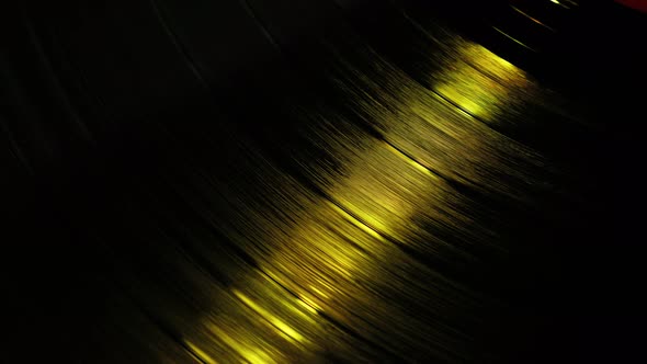 A Fragment of a Rotating Vinyl Record in the Red Rays of a Disco alt