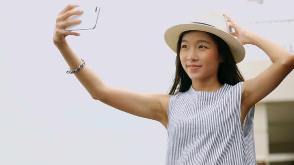 Beautiful Asian woman taking selfies on a smartphone.