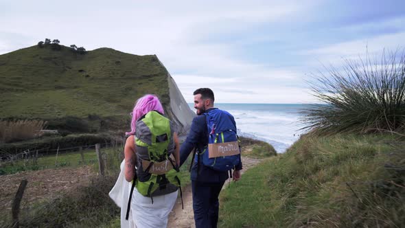 Slow motion shot of bridal couple walking to viewpoint alt