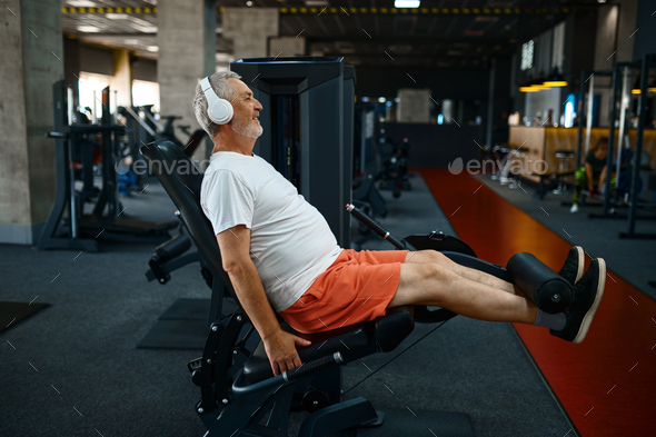 Elderly man in headphones doing abs exercise