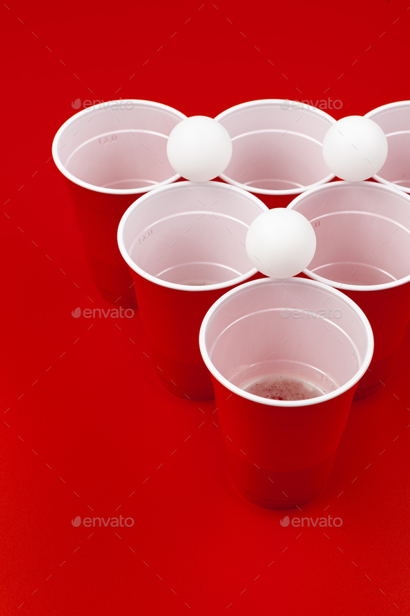 Cups and plastic ball for beer pong game on table Photos