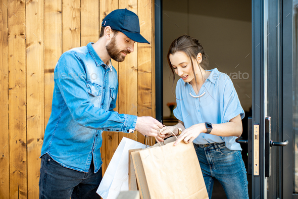 Delivery man bringing goods home for a woman client