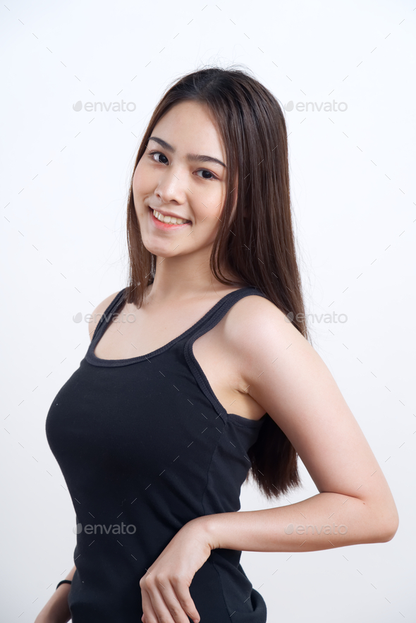 Young pretty and cute Asian girl in black lady vest standing with smile on  white background. Stock Photo by s_kawee