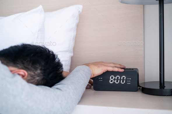 Lazy male office worker sleeping on bed in bedroom