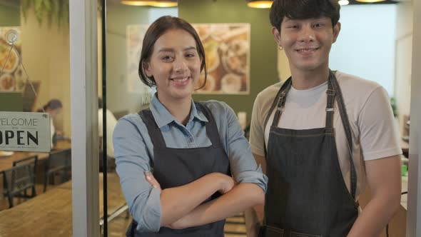 Portrait of Young couple restaurant owner in front of restaurant .