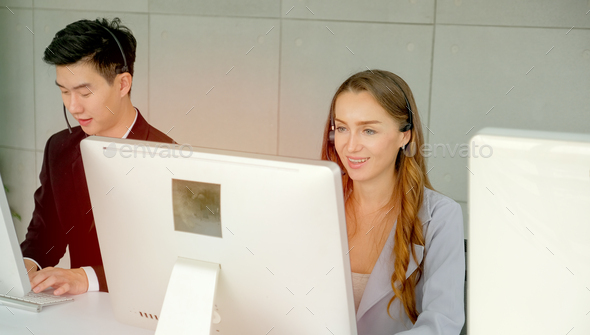 Beautiful pretty woman smile during work as operator or call center in front of big monitor