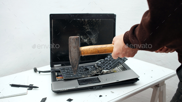 man destroyed laptop with a hammer. Nervous work, buggy computer, errors, slow Internet, not saved