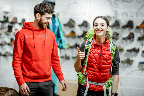 Woman trying backpack with man in the sports shop