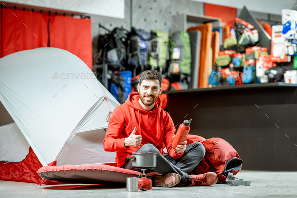 Man with camping tools and tent in the shop