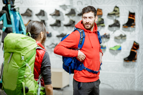 Couple trying backpacks in the sports shop