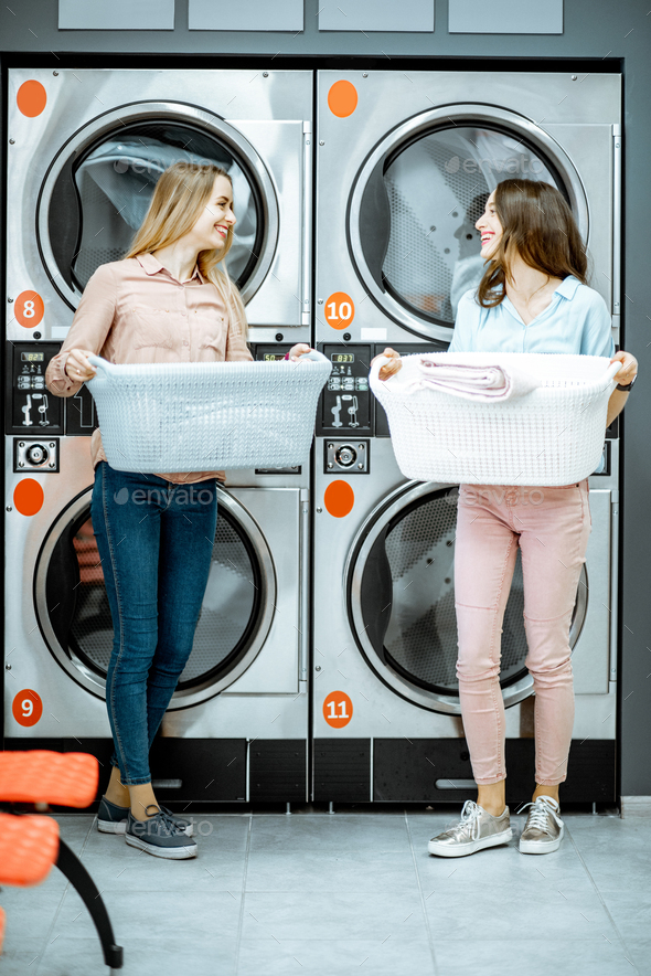 Women with clothes in the laundry Stock Photo by RossHelen PhotoDune