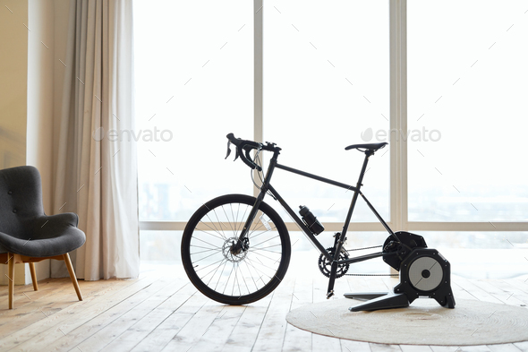 Stationery exercise bike in apartment with wooden floor