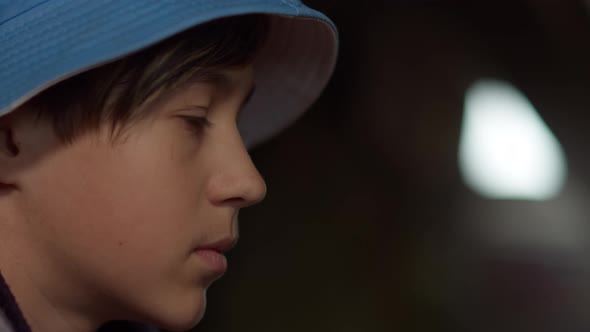 Profile of a Serious Sad Boy in a Hat Thinking About Something in an Abandoned House alt