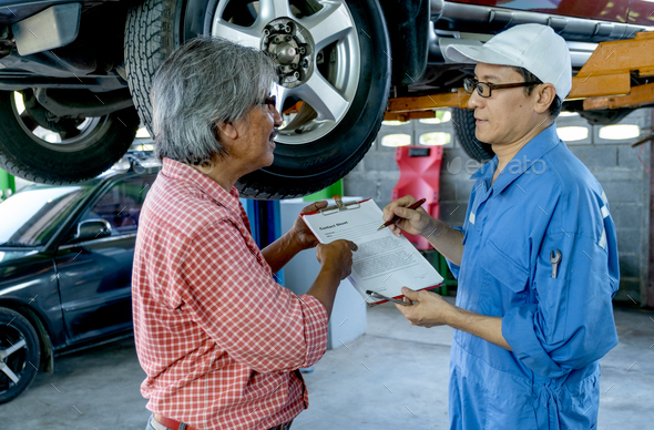 Asian automotive technician discuss about contact form to senior customer during service