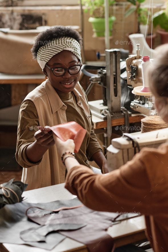 Tailors working with leather in the factory Stock Photo by AnnaStills