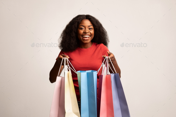Big Sales. Happy Black Lady Holding Lots Of Bright Paper Shopping Bags
