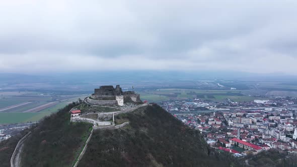Stunning Aerial View of the Medieval Stone Fortress of Deva on a Cloudy Day