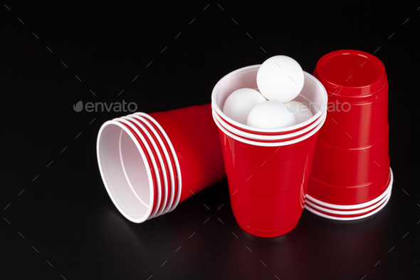 Red plastic cups and ball for game of beer pong Stock Photo by