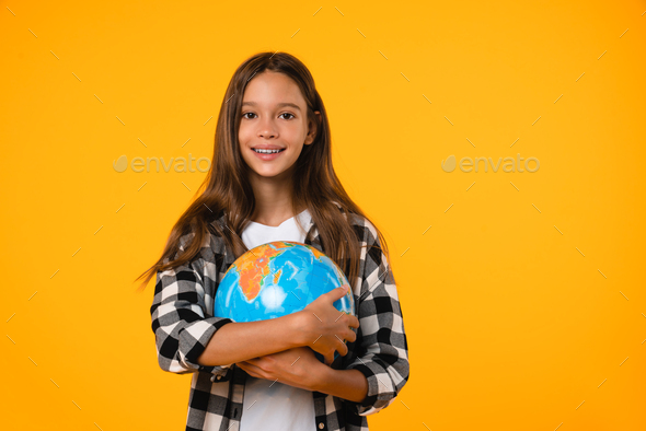 Earth day! Girl hugging globe on geography lesson isolated in yellow background.