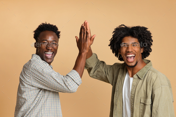 Two Cheerful Black Guys Giving High Five To Each Other