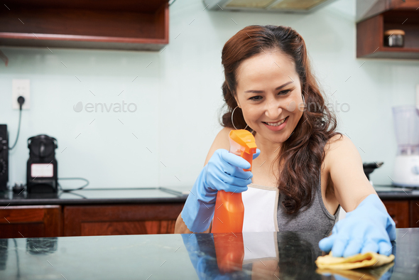 Housewife cleaning table Stock Photo by DragonImages