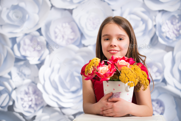 Little girl holding a bucket of flowers