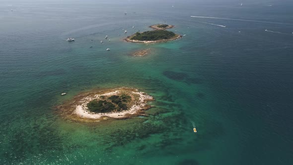 Boats moored near two tiny islands in Adriatic Sea alt