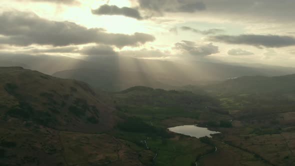 Sun shining above hills in Lake District National Park, Cumbria, UK