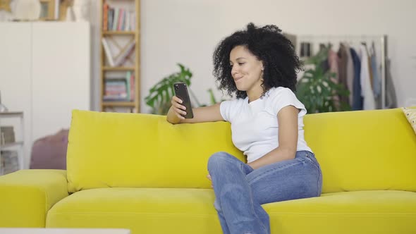 Portrait of a Young African American Woman Talking on a Video Call on Her Smartphone alt