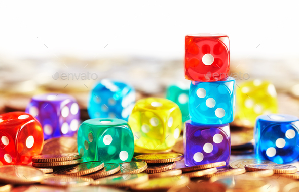Colorful dice on golden coins. - Stock Photo - Images