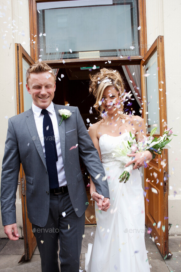 Confetti thrown at bride and groom at wedding ceremony Stock Photo by nualaimages