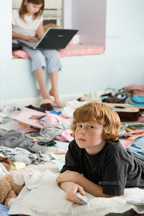 A boy and girl in a messy bedroom