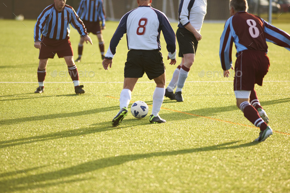 Football player with possession of ball Stock Photo by nualaimages