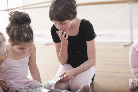 Girls swapping stickers in ballet school - Stock Photo - Images
