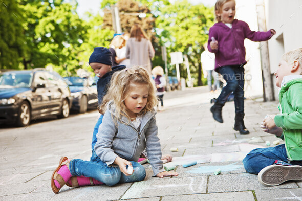 Children drawing on sidewalk with chalk