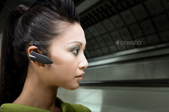 A woman wearing a bluetooth headset