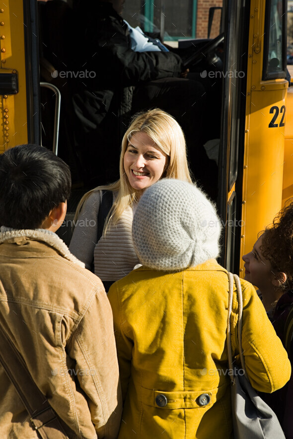 Children and teacher by school bus