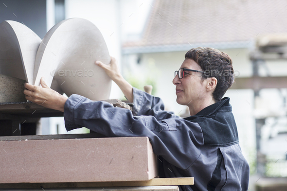 Stonemason lifting stone sculpture onto pallet Stock Photo by ...