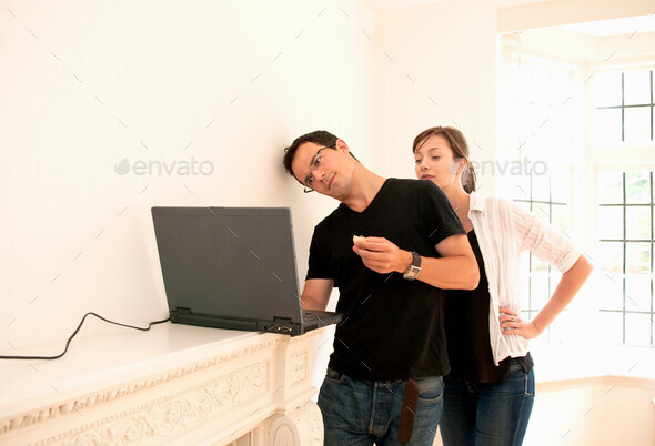 Couple check emails in new home