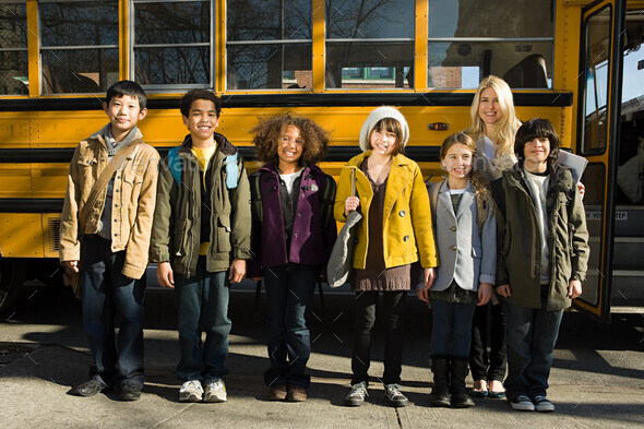 Children and teacher by school bus