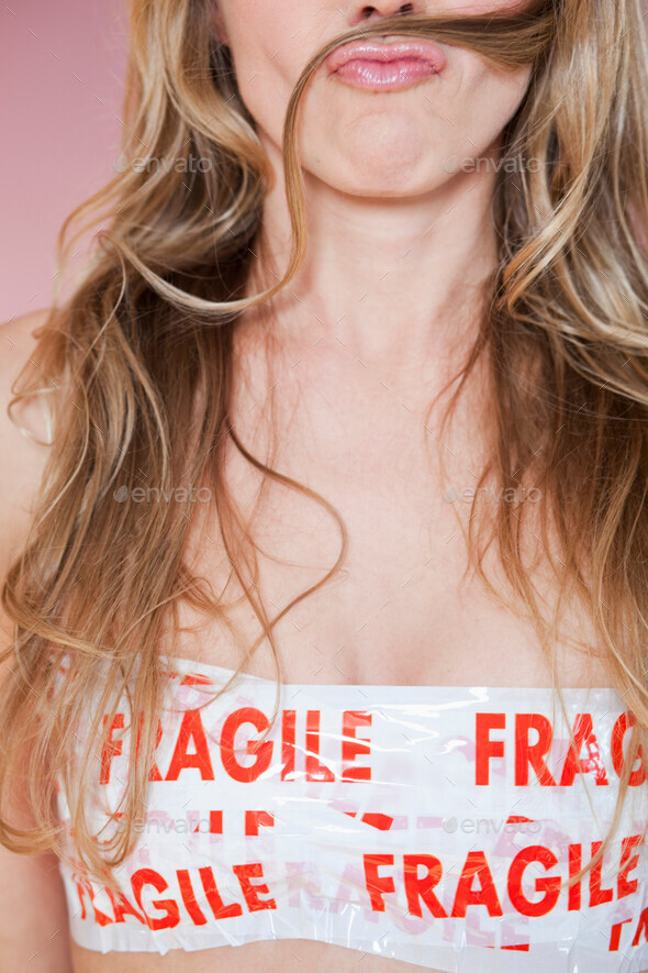 Closeup of woman wrapped in Fragile tape - Stock Photo - Images