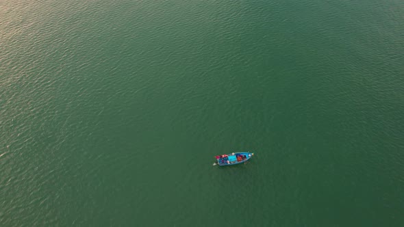 Fishing boat sailing in the sea near river mouth alt