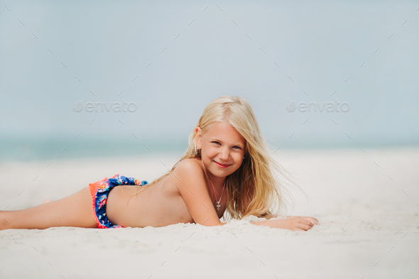 Adorable little girl at beach during summer vacation Stock Photo by Lobachad
