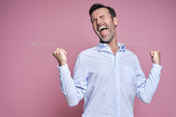 Man on pink background with hand raised - Stock Photo - Images