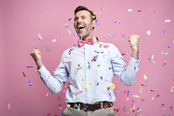 Studio shot of successful middle aged man celebrating achievement - Stock Photo - Images