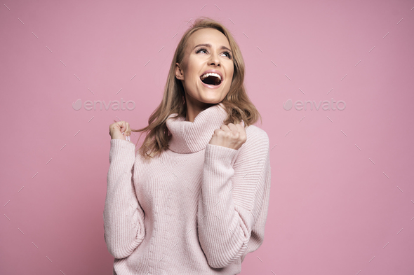Studio shot of smiling caucasian young woman with  clenched hand - Stock Photo - Images