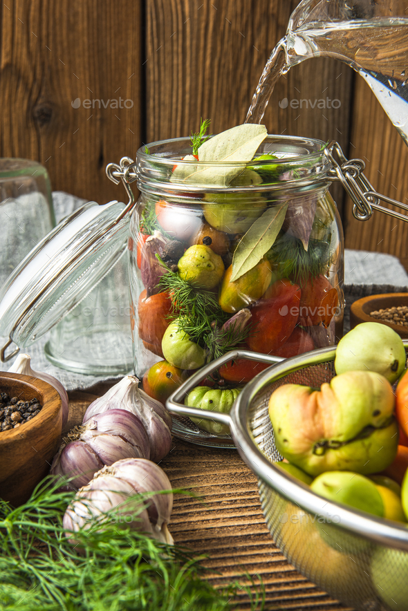 Pickled Tomatoes in Jar with Herbs and Garlic - Stock Photo - Images
