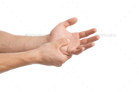 Cropped young caucasian guy presses his hand to sore spot to wrist and suffers from pain in arm